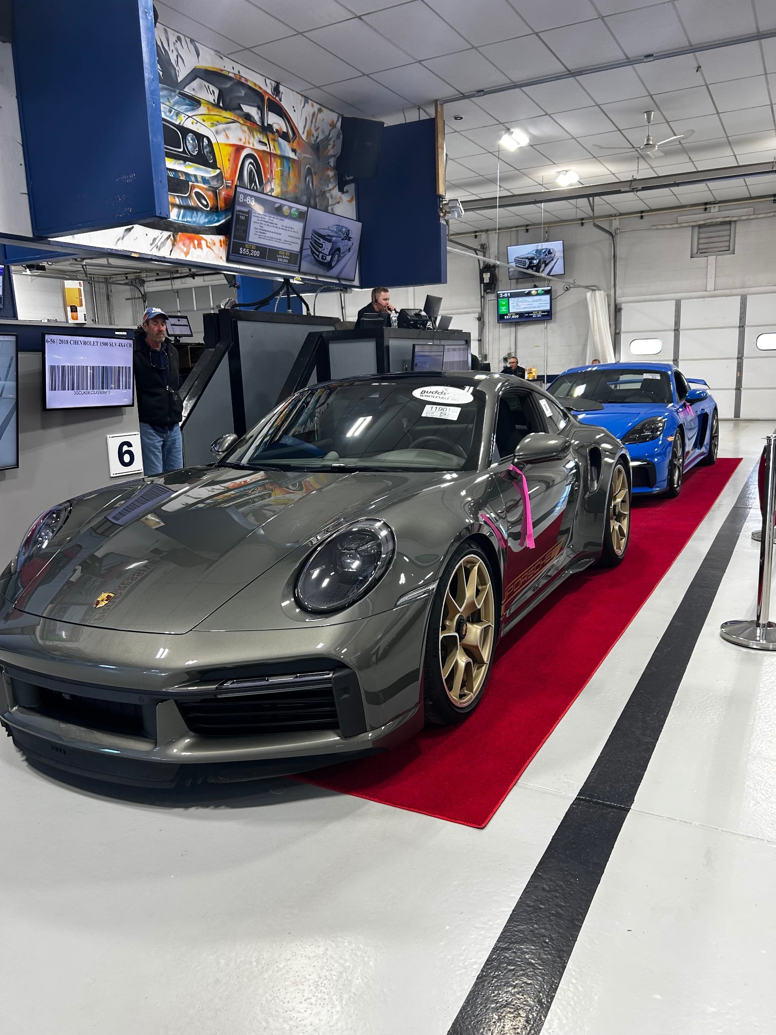 A Porsche rolling across the red carpet on the live auction lane floor